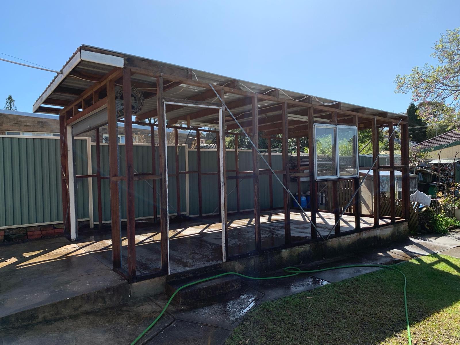 Shed after strip-back — cladding removed leaving the bare structural frame
