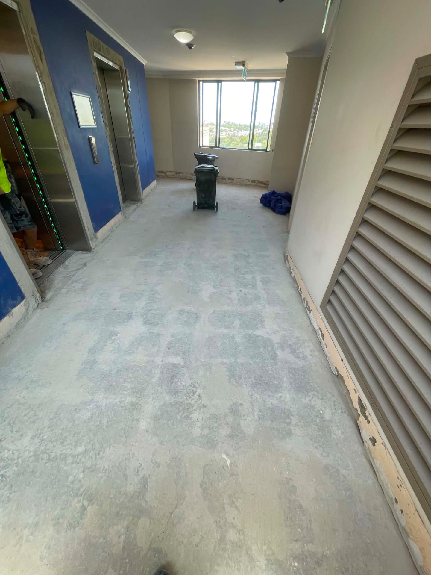 High-rise apartment lift lobby after commercial floor tile removal across 17 levels